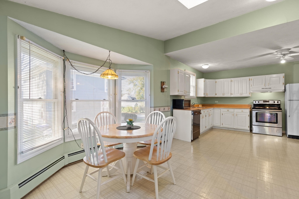 35 Roosevelt Street, Unit 35 Maynard, MA 01754 - Photo 20 of 39 a kitchen with stainless steel appliances kitchen island granite countertop a table and chairs in it