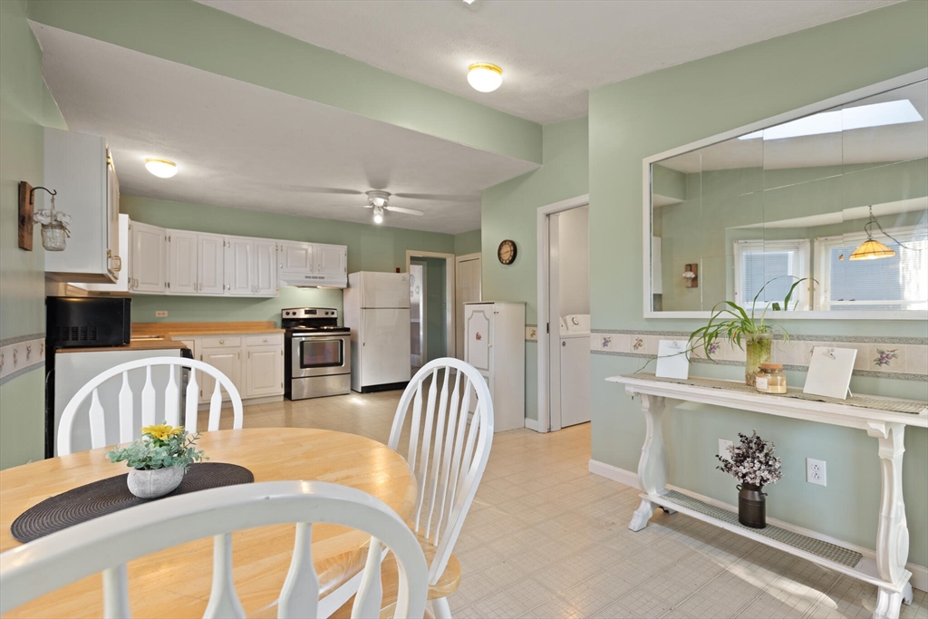 35 Roosevelt Street, Unit 35 Maynard, MA 01754 - Photo 22 of 39 a kitchen with stainless steel appliances kitchen island granite countertop a table chairs in it and wooden floors