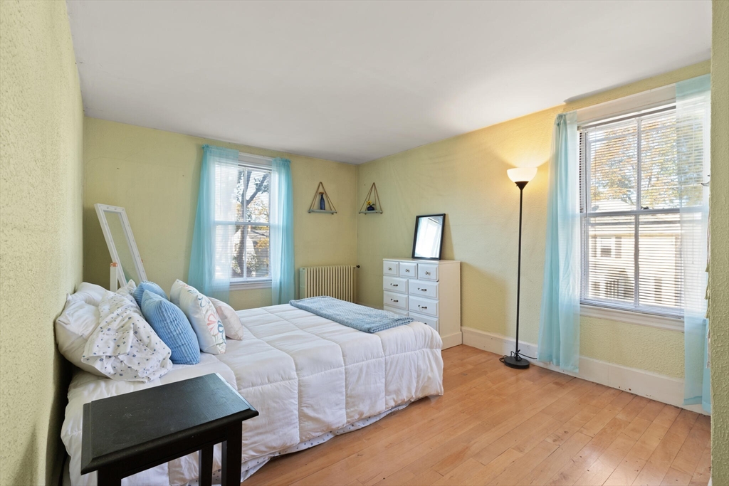 35 Roosevelt Street, Unit 35 Maynard, MA 01754 - Photo 29 of 39 a bedroom with a bed and wooden floor