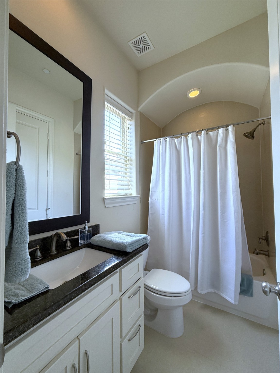 705 Delano Street Houston, TX 77003 - Photo 17 of 28 a bathroom with a granite countertop sink toilet a mirror and a tub