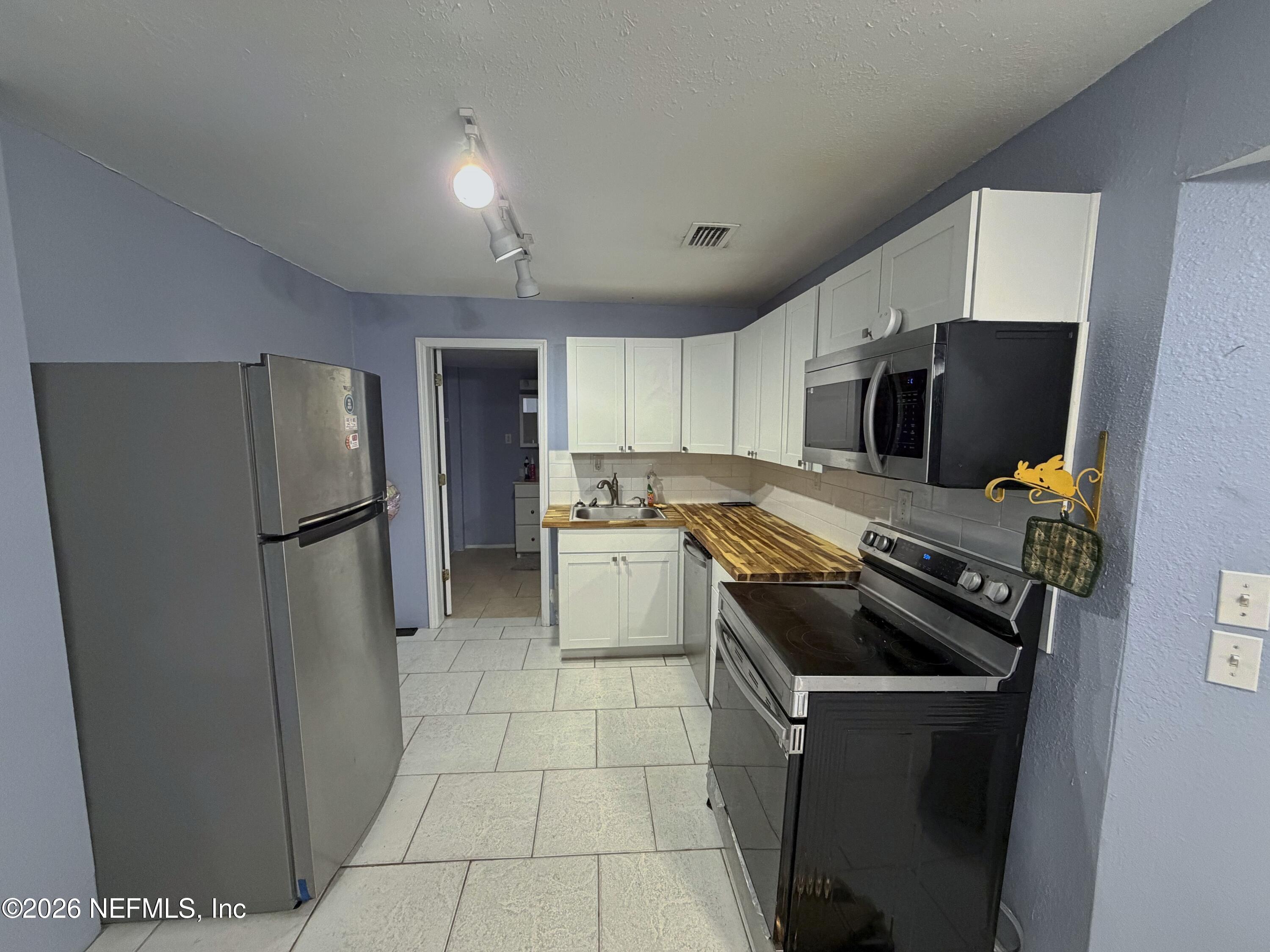 8 10th Street, Unit B St. Augustine, FL 32080 - Photo 3 of 14 a kitchen with a refrigerator sink and cabinets
