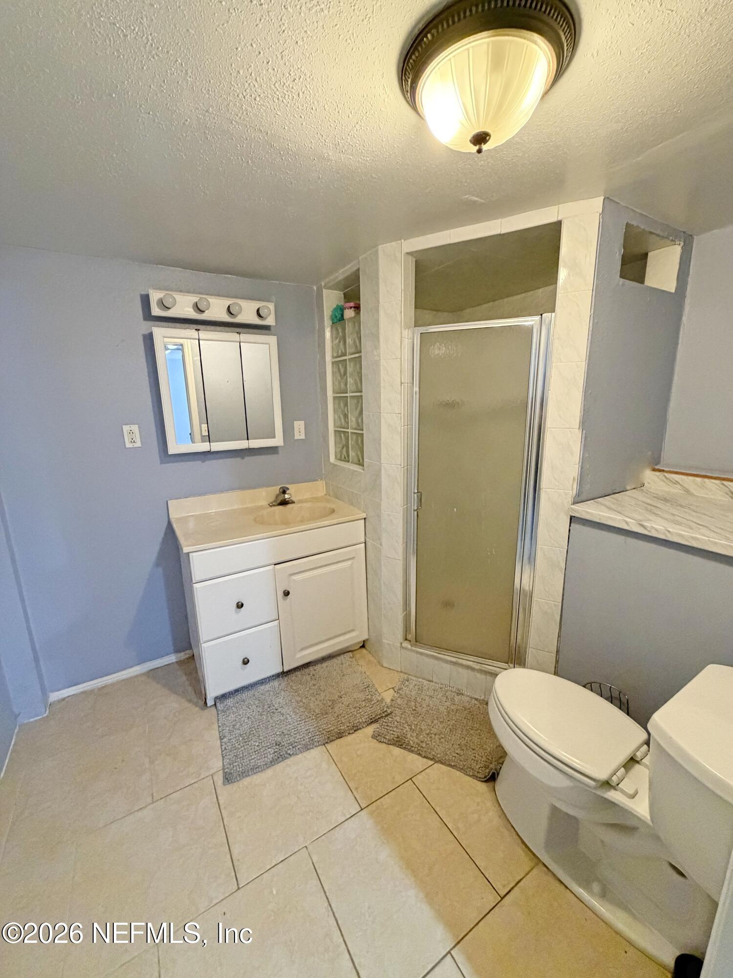 8 10th Street, Unit B St. Augustine, FL 32080 - Photo 6 of 14 a bathroom with a sink a toilet and a mirror