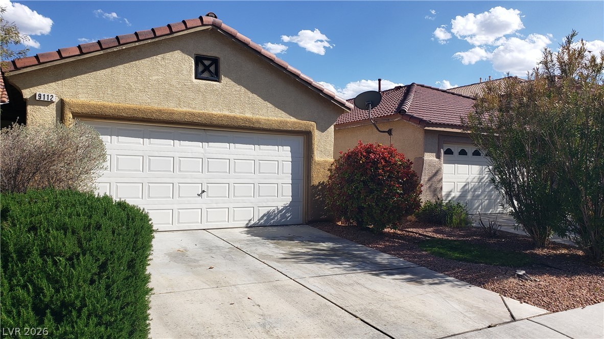 9112 Manalang Road Las Vegas, NV 89123 - Photo 1 of 50 A terracotta-tiled roof crowns this stucco-finished residence, featuring a dual garage and a concrete driveway.