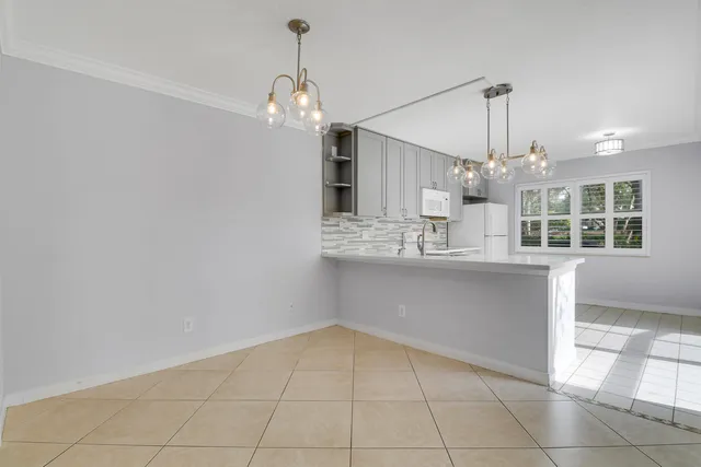 a view of kitchen with granite countertop cabinets and chandelier