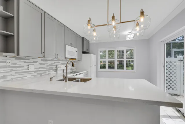 a view of a kitchen with a sink and chandelier