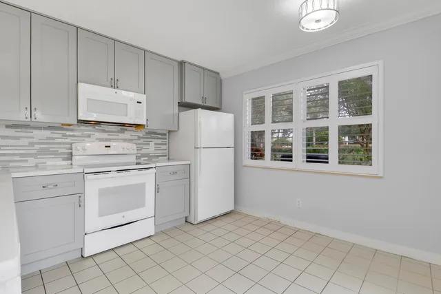 a kitchen with white cabinets and white appliances