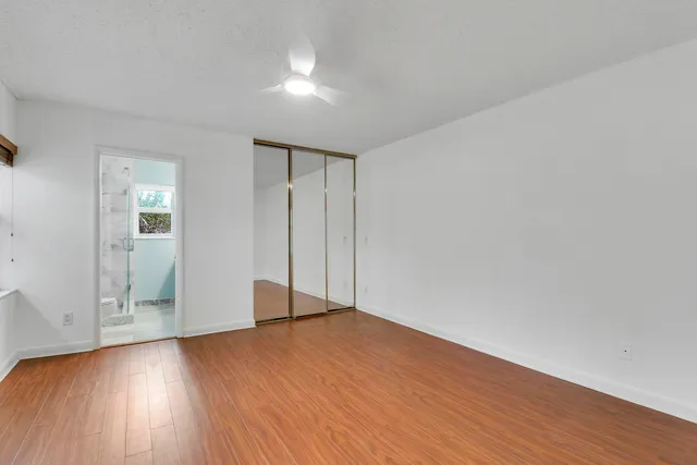 a view of an empty room with wooden floor