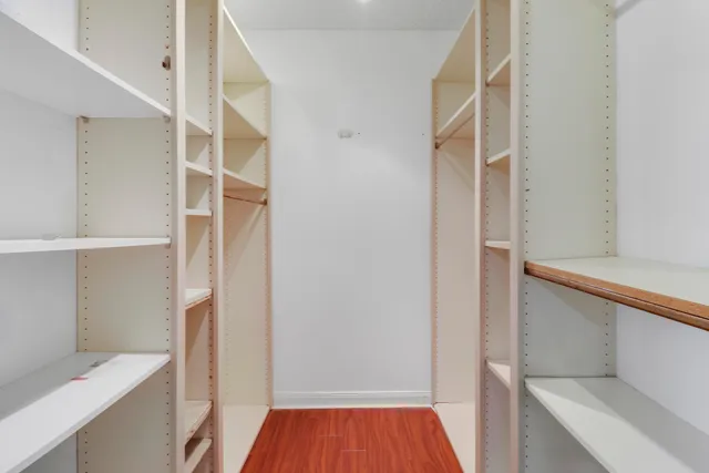 a view of walk in closet with wooden floor