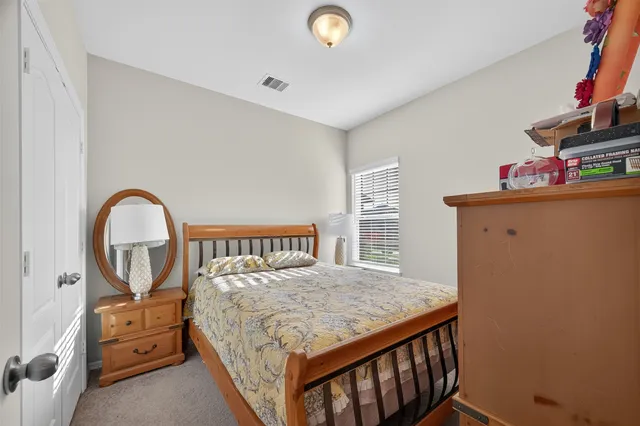 a bedroom with a bed and a dresser next to it