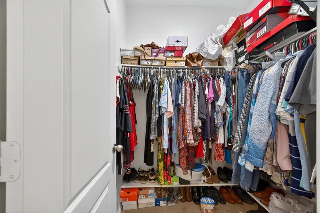 a view of walk in closet with clothes