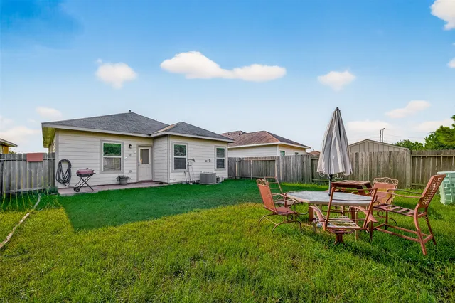 a view of a house with a backyard and chairs