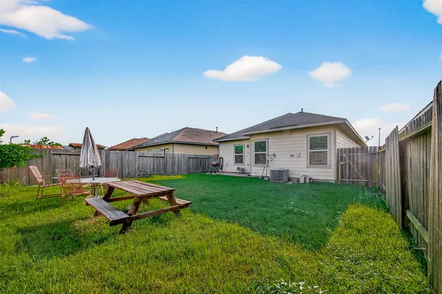 a backyard of a house with table and chairs