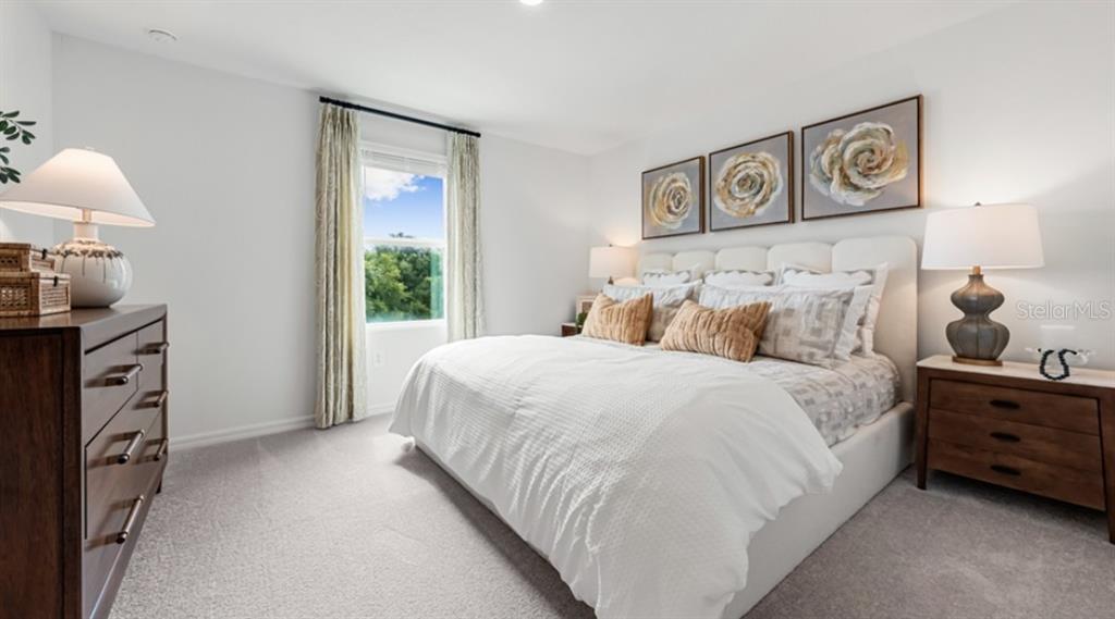 13134 Stable Place Parrish, FL 34219 - Photo 7 of 28 a bedroom with a bed and a lamp on dresser