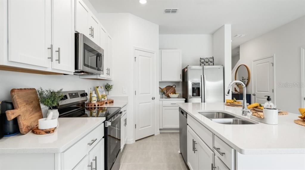 13134 Stable Place Parrish, FL 34219 - Photo 9 of 28 a kitchen with stainless steel appliances granite countertop a sink stove and cabinets