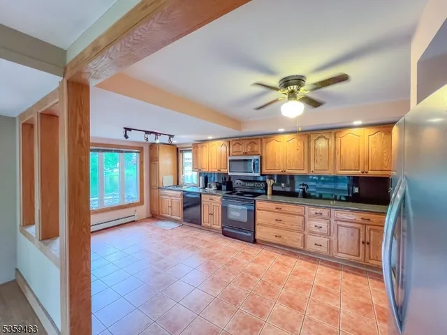 a large kitchen with a large window a sink and stainless steel appliances
