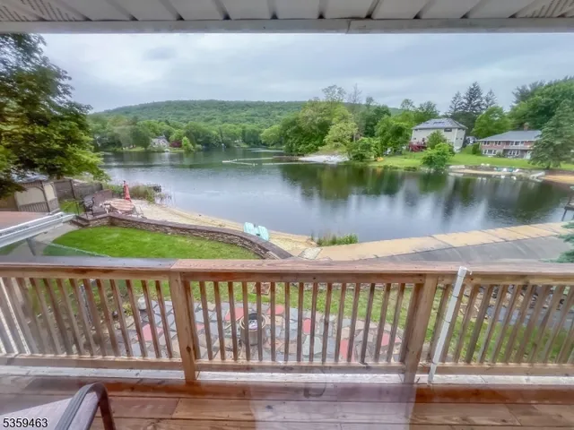 a balcony with wooden floor and lake view