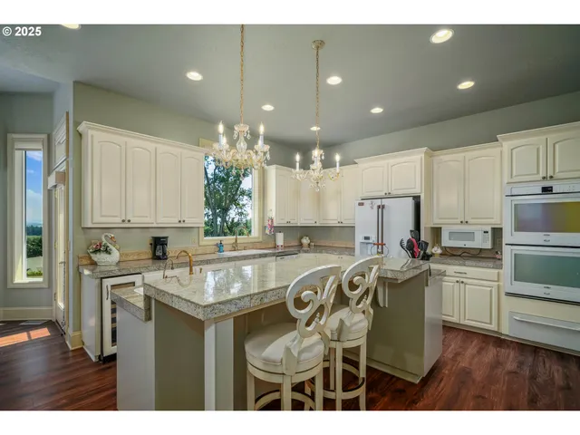a kitchen with stainless steel appliances granite countertop a sink a stove a refrigerator and island