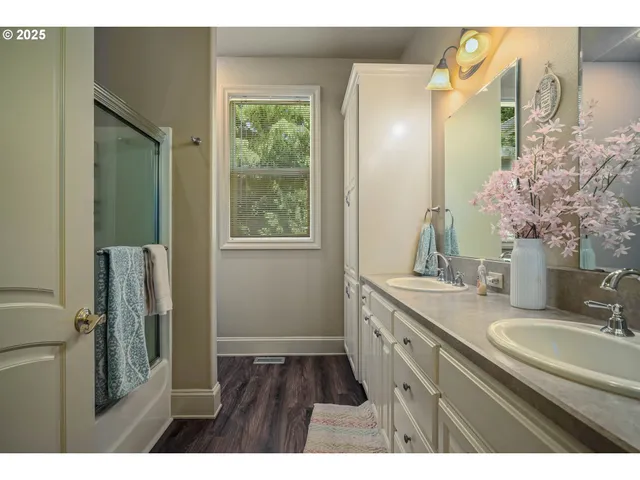 a bathroom with a granite countertop sink a mirror a vanity and a shower
