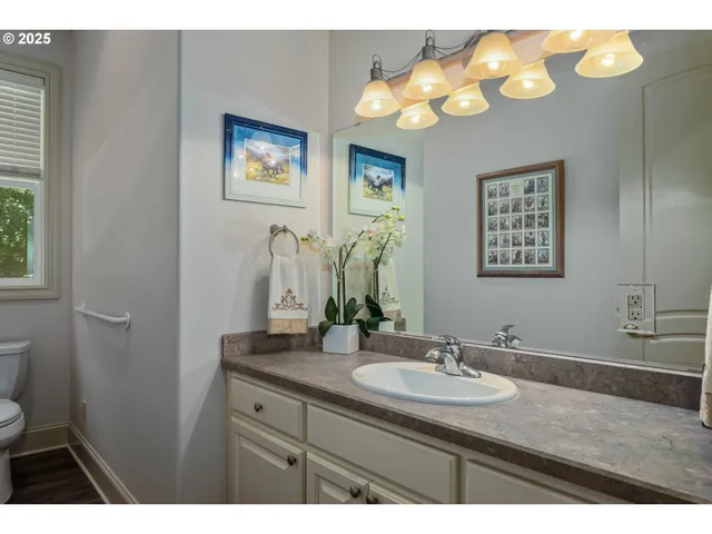 a bathroom with a granite countertop sink a toilet and a mirror