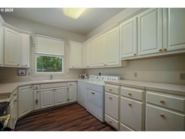 a kitchen with kitchen island granite countertop white cabinets and white appliances