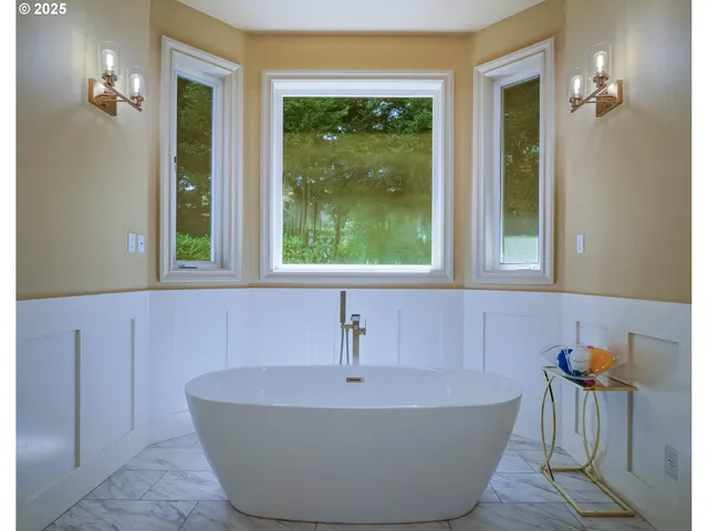 a bath tub sitting in a bathroom next to a window