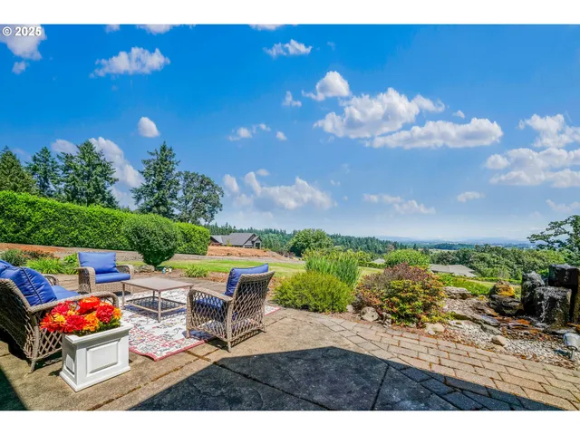 a view of a backyard with plants and outdoor seating