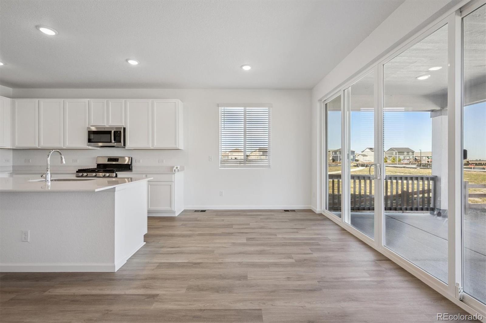 45929 Gentry Avenue Bennett, CO 80102 - Photo 8 of 24 a kitchen with granite countertop a stove a sink and a refrigerator
