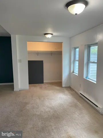 an empty room with windows and closet