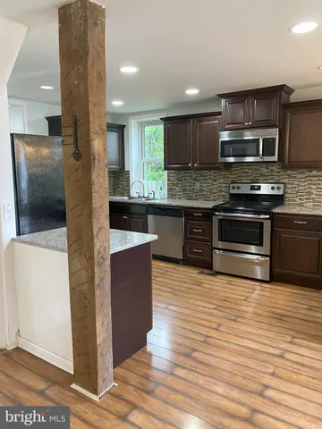 a kitchen with stainless steel appliances granite countertop a stove a sink and a microwave