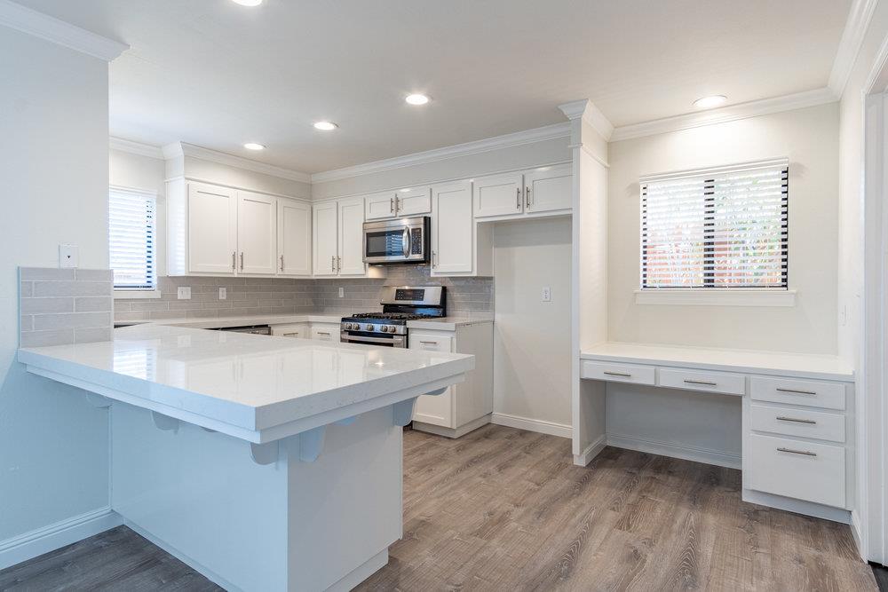 1220 Heather Glen Circle Hollister, CA 95023 - Photo 15 of 41 a kitchen with a refrigerator a sink and white cabinets