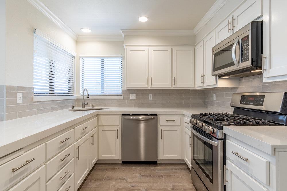 1220 Heather Glen Circle Hollister, CA 95023 - Photo 17 of 41 a kitchen with stainless steel appliances granite countertop white cabinets a sink dishwasher a stove and a granite counter top