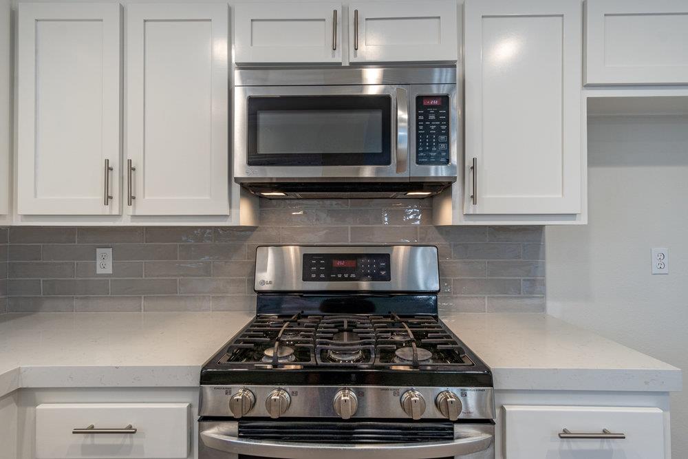 1220 Heather Glen Circle Hollister, CA 95023 - Photo 19 of 41 a kitchen with granite countertop a stove and a microwave