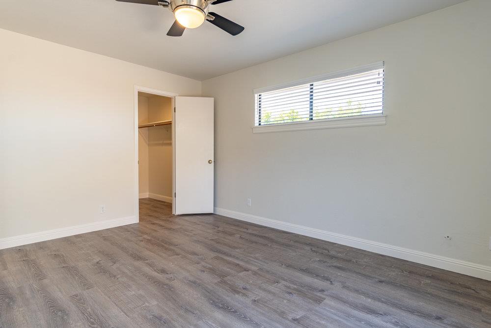 1220 Heather Glen Circle Hollister, CA 95023 - Photo 26 of 41 an empty room with wooden floor fan and windows
