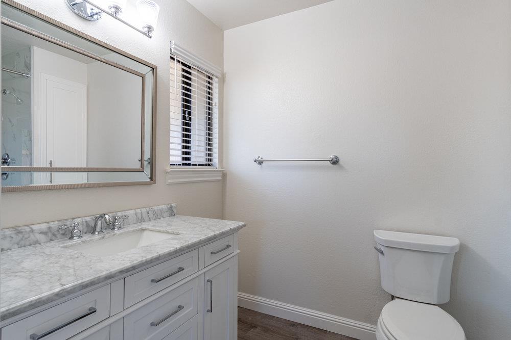 1220 Heather Glen Circle Hollister, CA 95023 - Photo 27 of 41 a bathroom with a granite countertop toilet sink and mirror