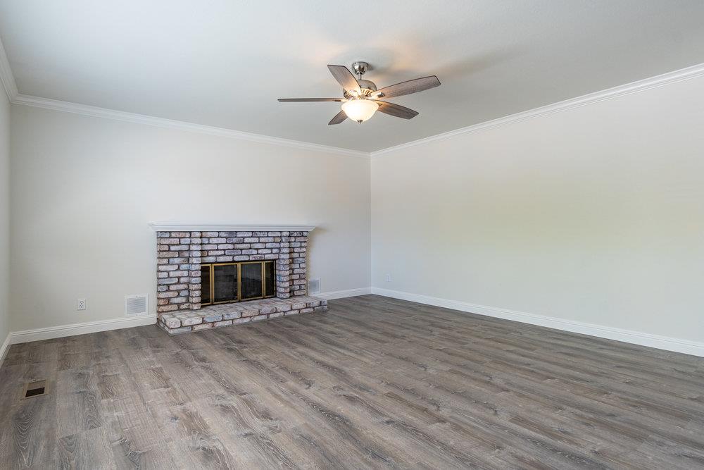 1220 Heather Glen Circle Hollister, CA 95023 - Photo 7 of 41 a view of an empty room with wooden floor fireplace and a window