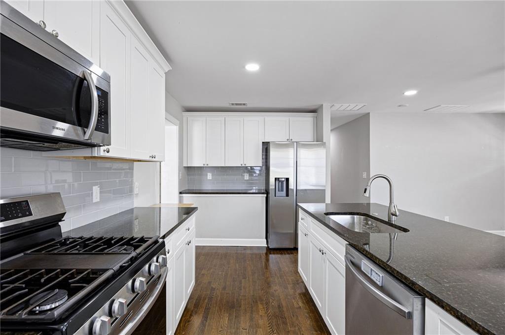 45 Smyrna Powder Springs Road Southeast Marietta, GA 30060 - Photo 12 of 45 a kitchen with stainless steel appliances granite countertop a stove a sink and a microwave