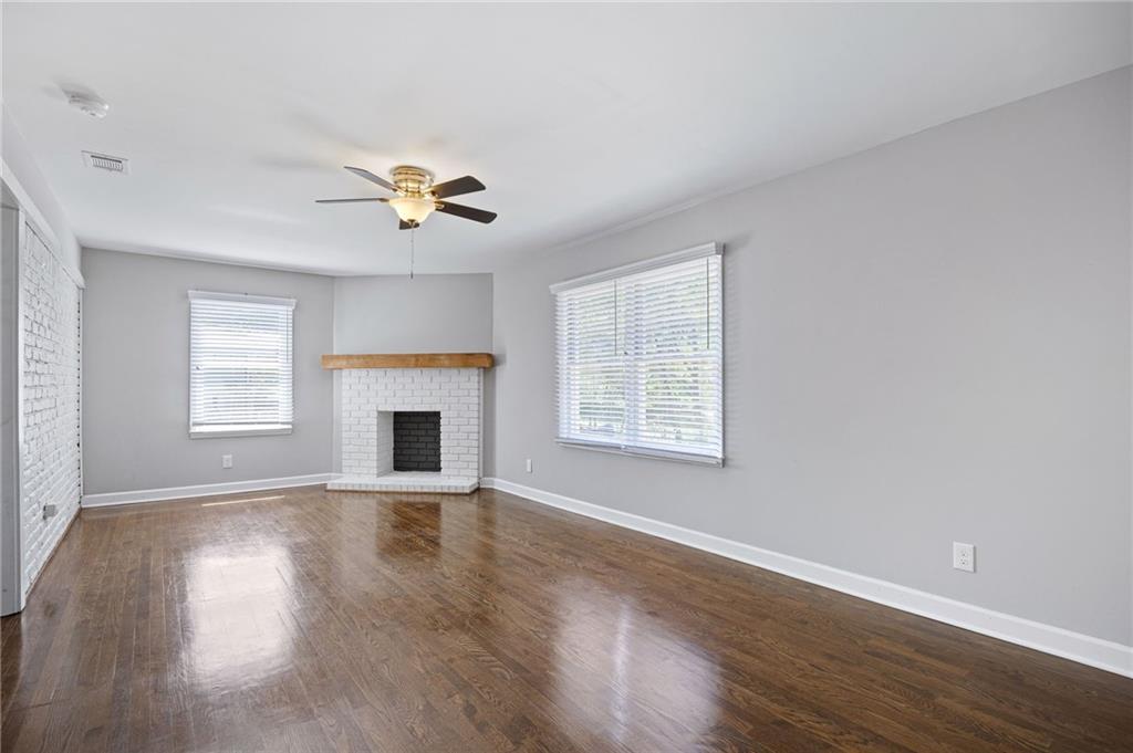 45 Smyrna Powder Springs Road Southeast Marietta, GA 30060 - Photo 15 of 45 an empty room with windows fireplace and a chandelier fan