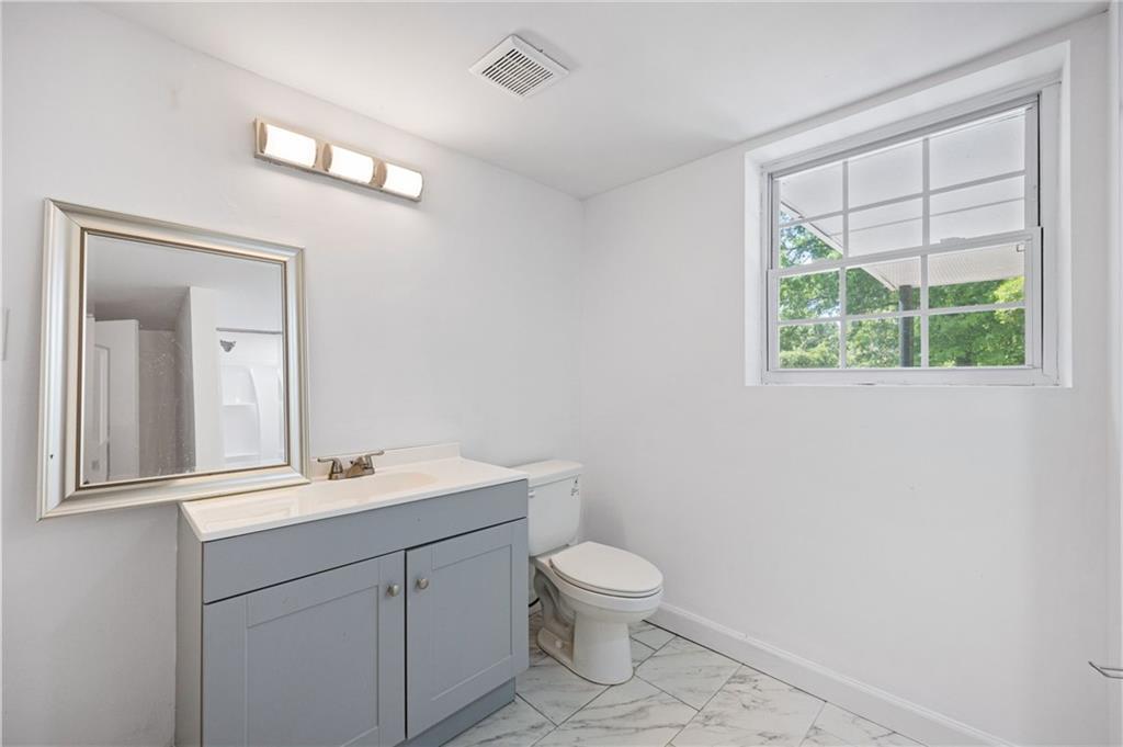 45 Smyrna Powder Springs Road Southeast Marietta, GA 30060 - Photo 32 of 45 a bathroom with a toilet a sink a mirror and a window
