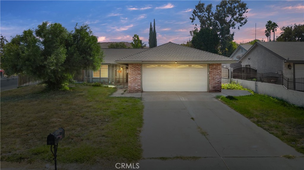 a front view of house with a garden