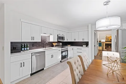 a kitchen with white cabinets and white appliances