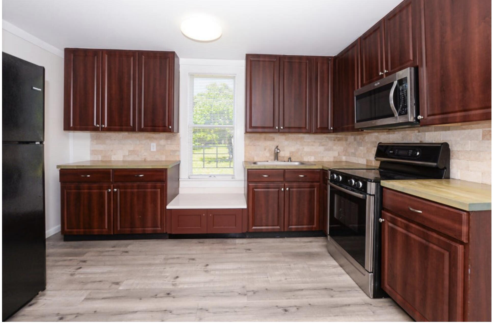 119 South 11th Street Fort Pierce, FL 34950 - Photo 18 of 22 a kitchen with stainless steel appliances granite countertop wooden cabinets a stove top oven a sink and dishwasher