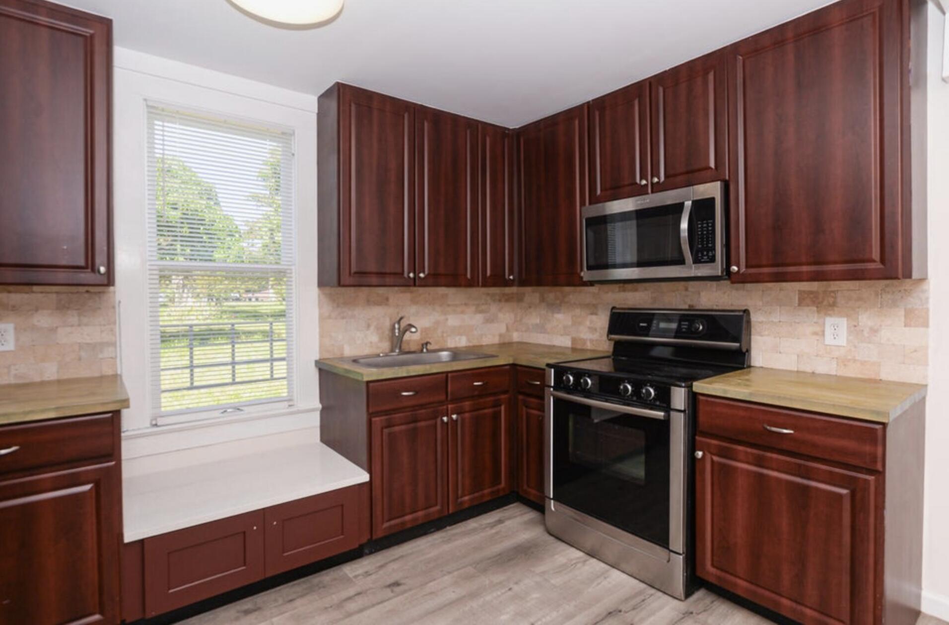 119 South 11th Street Fort Pierce, FL 34950 - Photo 20 of 22 a kitchen with granite countertop wooden cabinets and stainless steel appliances