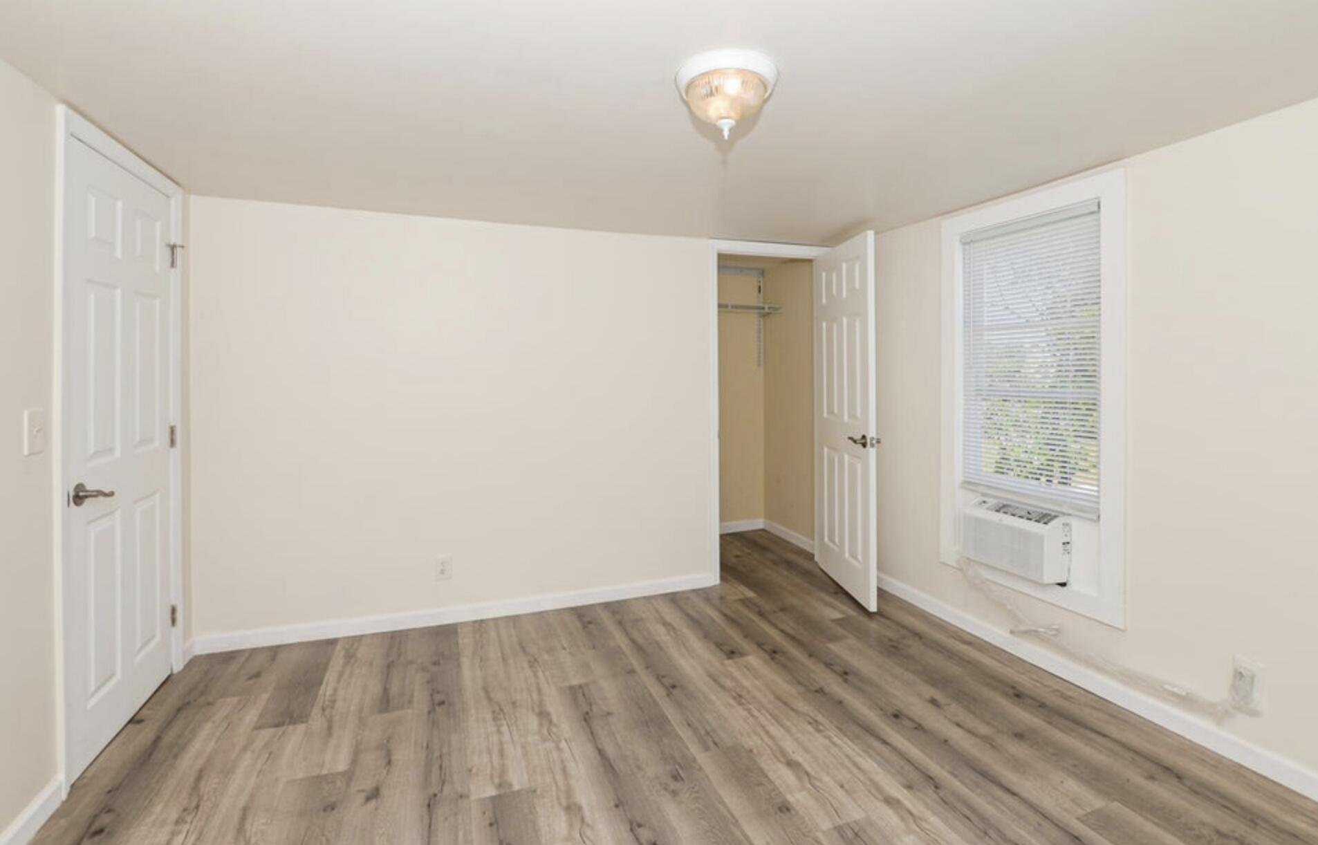 119 South 11th Street Fort Pierce, FL 34950 - Photo 6 of 22 a view of an empty room with wooden floor and a window