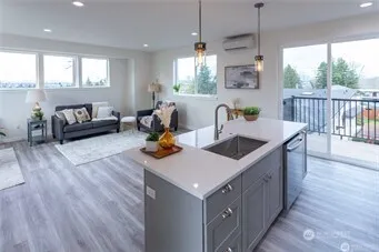 a kitchen with a stove a refrigerator a sink dishwasher with a dining table and chairs with wooden floor