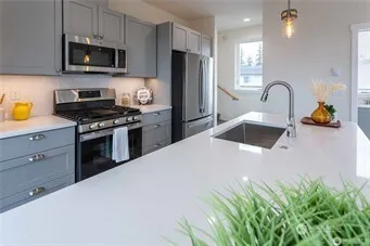a kitchen with stainless steel appliances granite countertop a stove a sink and a refrigerator