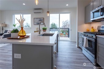 1024 North 8th Street Mount Vernon, WA 98273 - Photo 6 of 37 a kitchen with stainless steel appliances a stove top oven a sink and a dining table with wooden floor