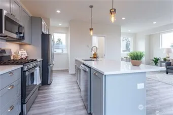 a kitchen with stainless steel appliances kitchen island a sink stove and refrigerator