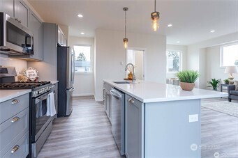 1024 North 8th Street Mount Vernon, WA 98273 - Photo 7 of 37 a kitchen with stainless steel appliances kitchen island a sink stove and refrigerator