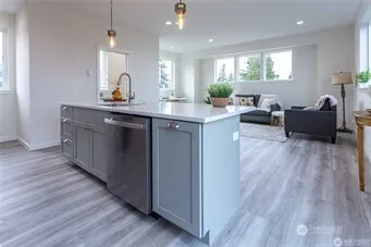 a view of living room with kitchen island hardwood floor and a window