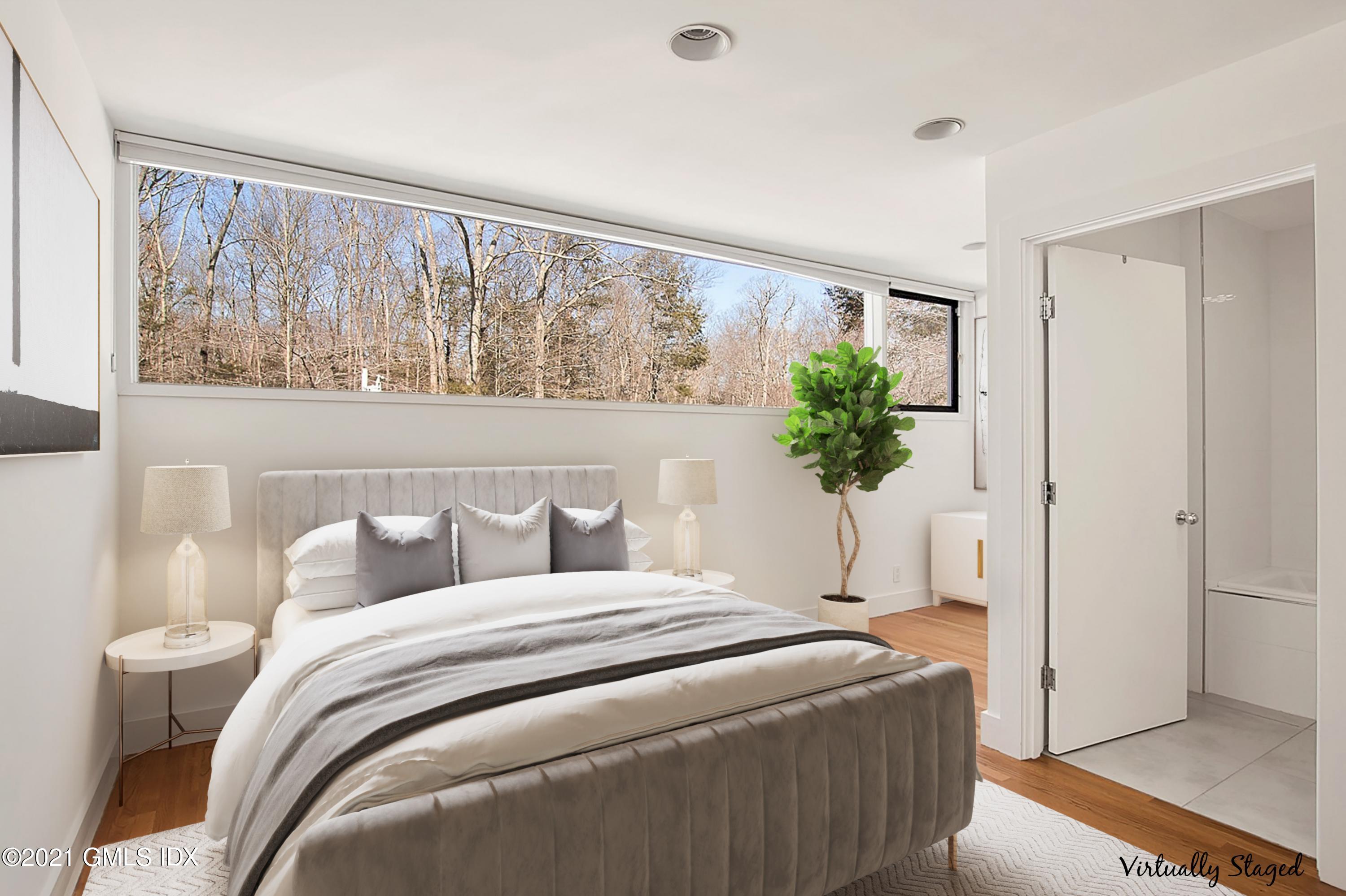 15 Hycliff Road Greenwich, CT 06831 - Photo 12 of 27 a bedroom with a large bed and a potted plant